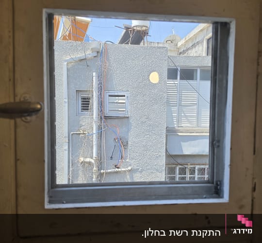 נוף חיצוני דרך חלון עם קיר חיצוני של בניין